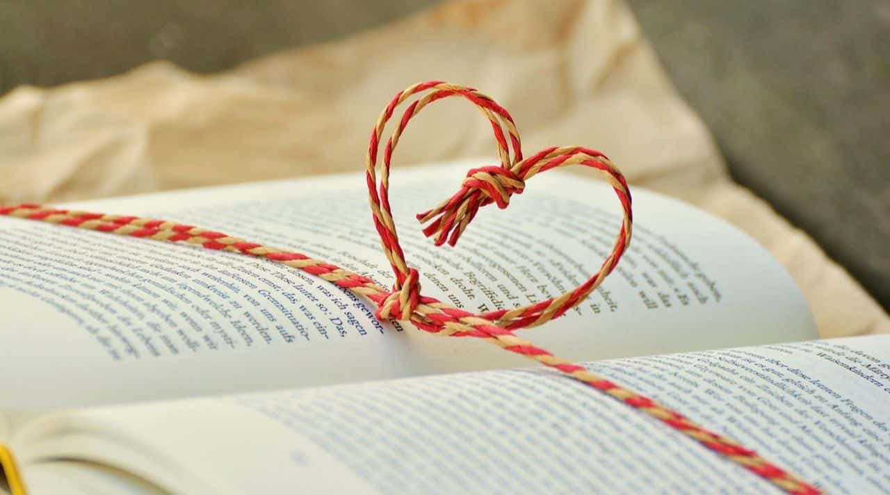 Red-and-natural twine shaped into a heart on an open book, illustrating free gift ideas when you have no money.