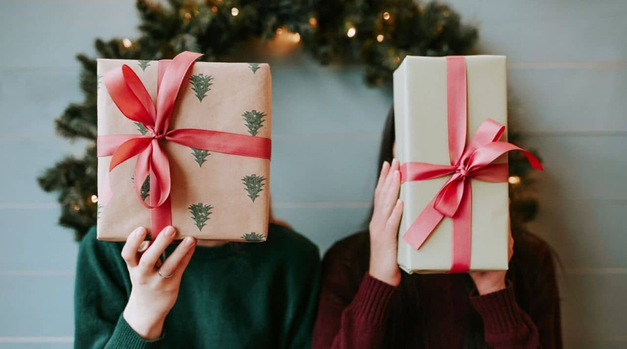 Is It Okay to Regift? Two people holding wrapped gifts during the holiday season